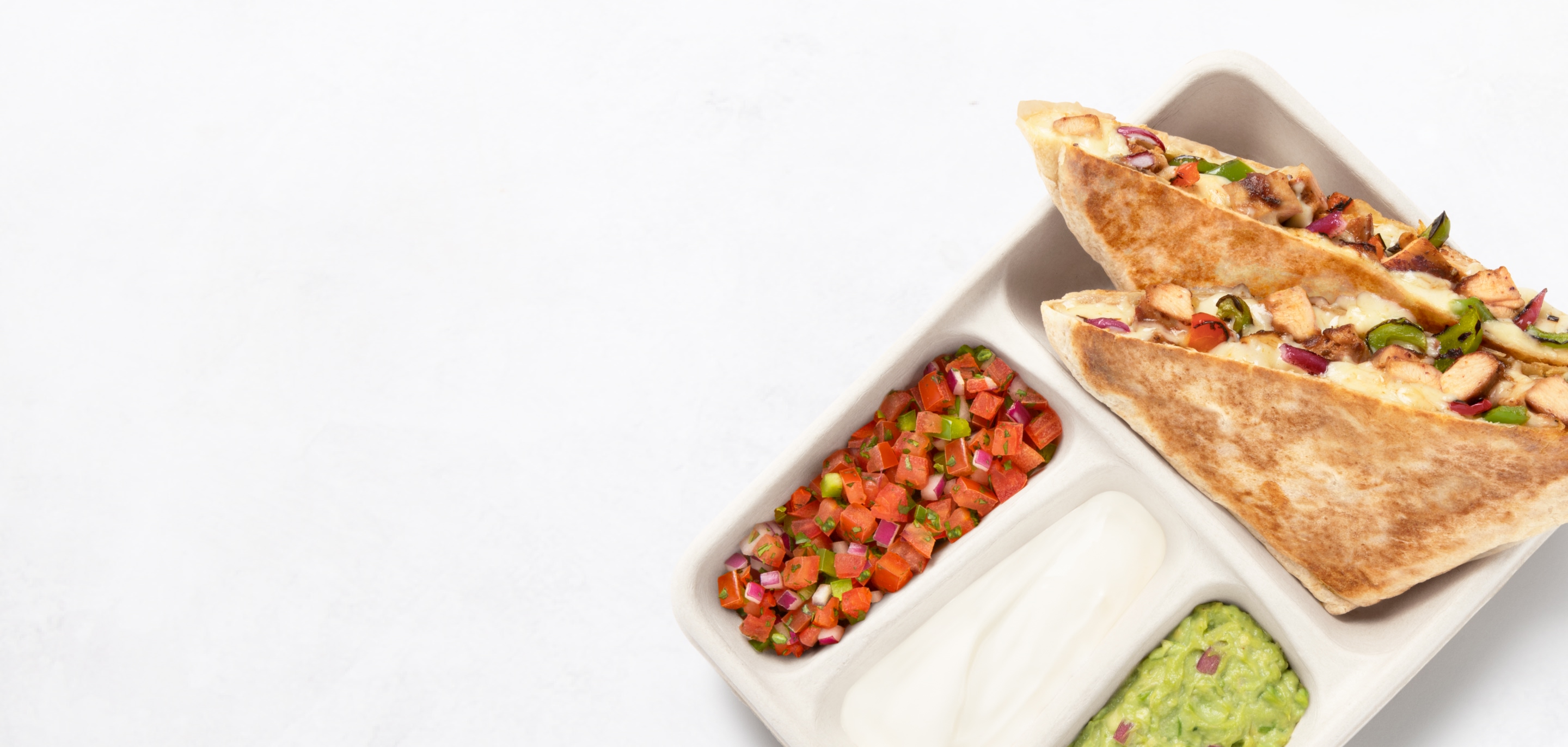 A freshly made to order Chicken Fajita Quesadilla with a side of fresh made Guac, Sour Cream, and Fresh Tomato Salsa.